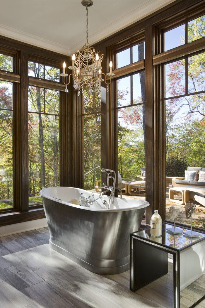 Interior, vertical, lower level bathroom toward tub looking out to patio and fall color, Bowden residence, Balsam Mountain Preserve, North Carolina; M. Shawn Leatherwood & Associates; Morgan Keefe Builders