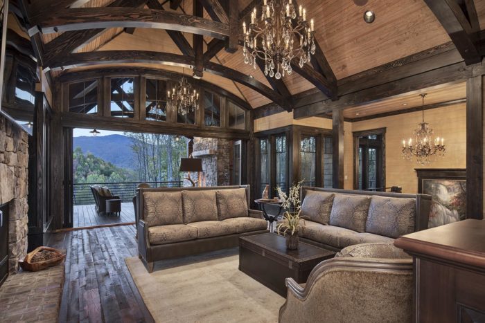 Interior, horizontal, living room toward stairway and looking out bifold doors to patio at twilight, Lemonine residence, Balsam Mountain Preserve, North Carolina; M. Shawn Leatherwood & Associates; Morgan-Keefe Builders
